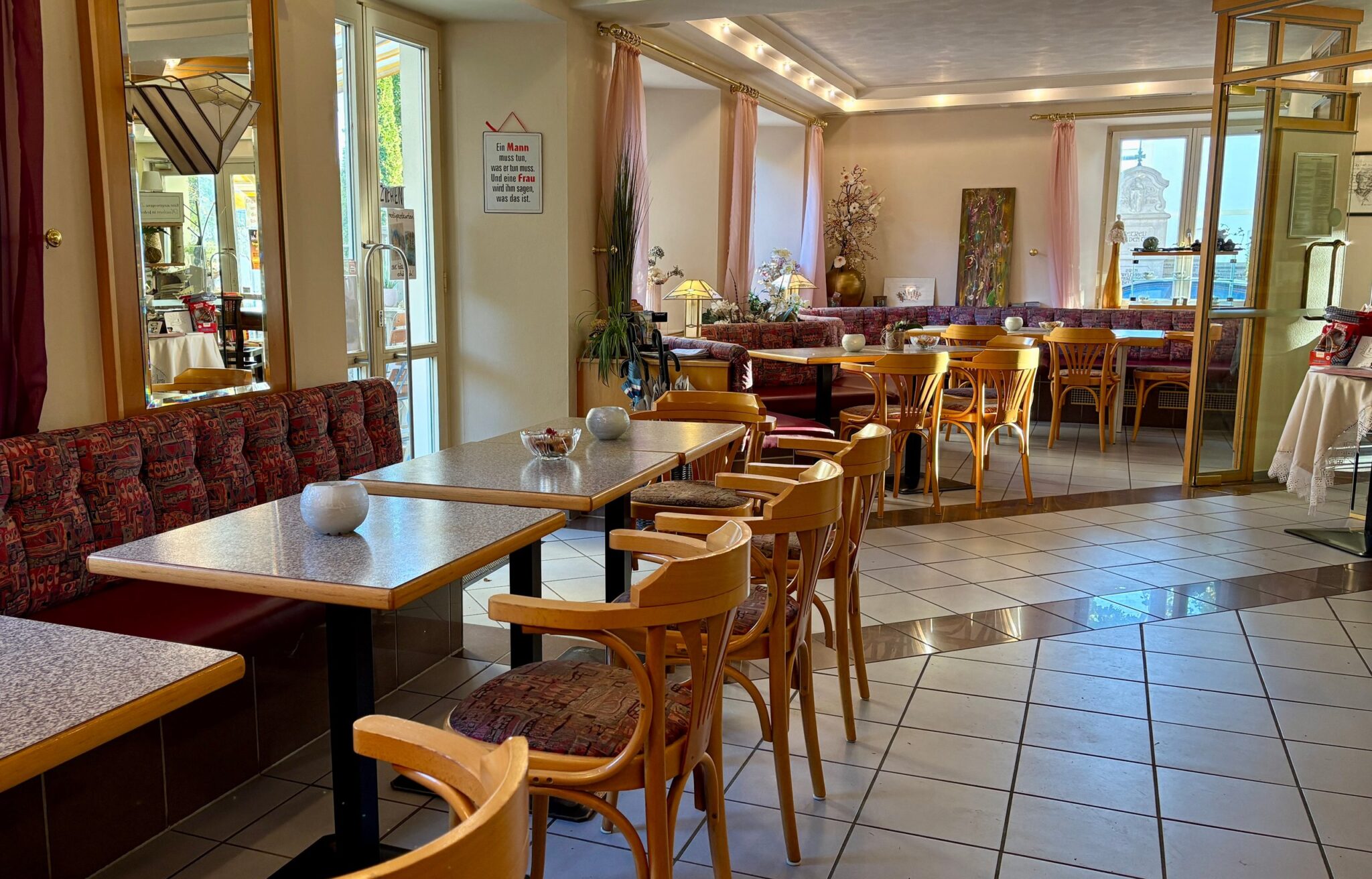 Gastraum des Café am Kirchplatz mit gepolsterten Sitzbänken und Holzstühlen