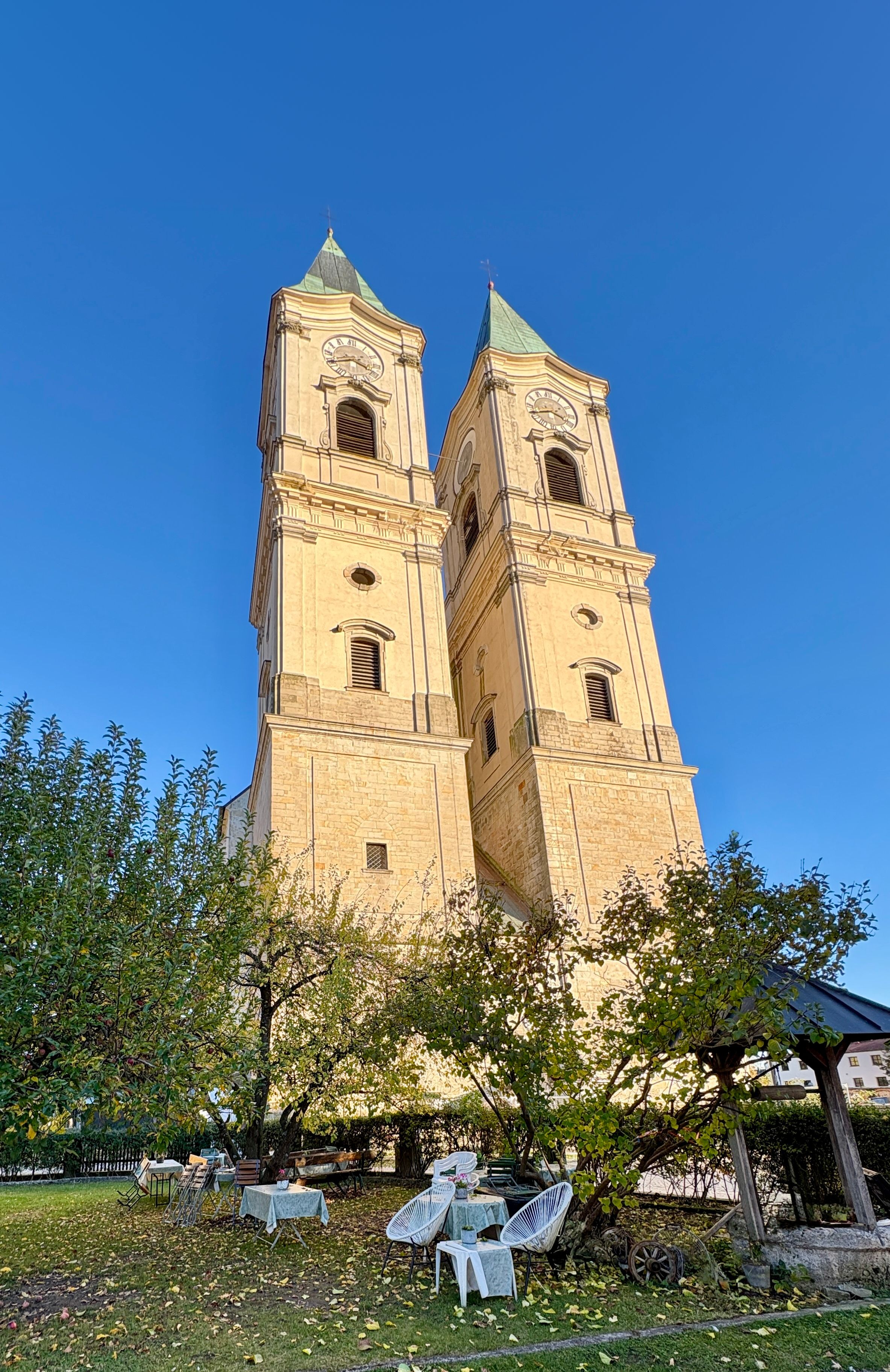 Türme der Basilika Niederalteich über dem Garten des Café am Kirchplatz